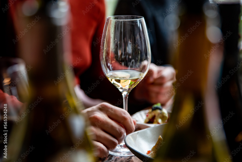 man hand hold glass of white wine on the table