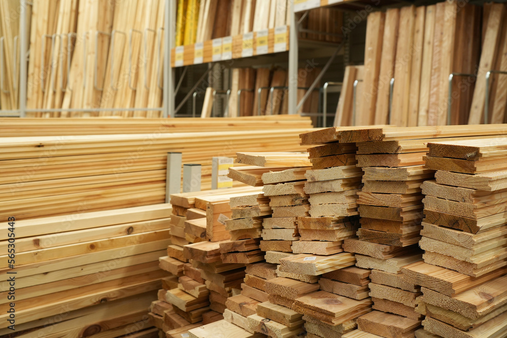 Obraz premium Pile of wood on store shelves. Wooden boards, lining, boards for construction work are presented in the hardware store. Building and finishing materials store