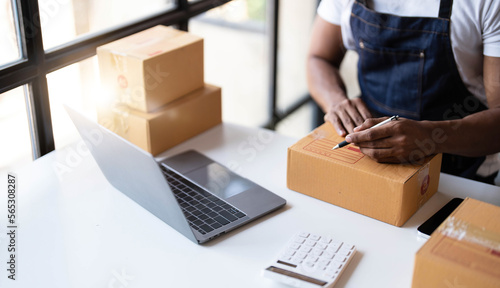 Starting small businesses SME owners male entrepreneurs Write the address on receipt box and check online orders to prepare to pack the boxes, sell to customers, sme business ideas online. © wichayada