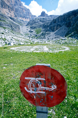 Rustic sign showing a hand painted helicopter in front of a helicopter landing spot in the Italian Dolomites near rifugio Brentei. Trentino, Italy. photo