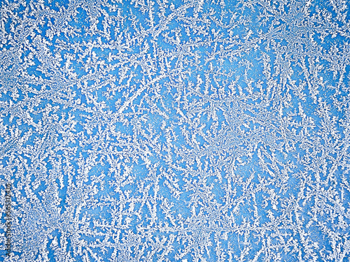 Winter abstract background. Snowflake pattern on a blue background. Macro texture. Natural background. View from above.