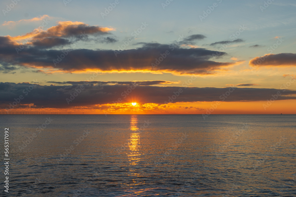 The sunsetting over the English Channel viewed from Brighton Beach, UK