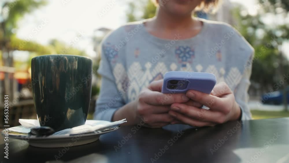 Close up hands of woman using phone in coffee shop. Person enjoying web surfing useful information, communicating distantly in social networks, playing mobile games or shopping in internet store. Close up hands of woman using phone in coffee shop. Person enjoying web surfing useful information, communicating distantly in social networks, playing mobile games or shopping in internet store.
