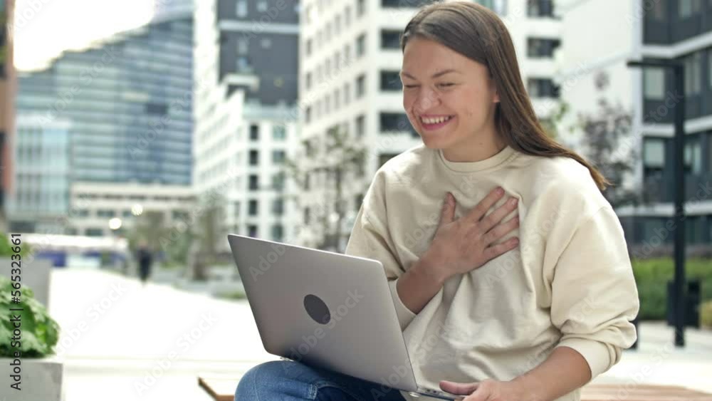 Young woman works remotely. A business woman with a laptop on her lap rejoices at the results of her work. Young woman works remotely. A business woman with a laptop on her lap rejoices at the results of her work.