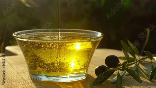 early harvest olive oil. pouring olive oil close up. oil made of fresh harvested olives. beginning of the harvest season, high quality olive oil produce. sustainable farming, local food. 