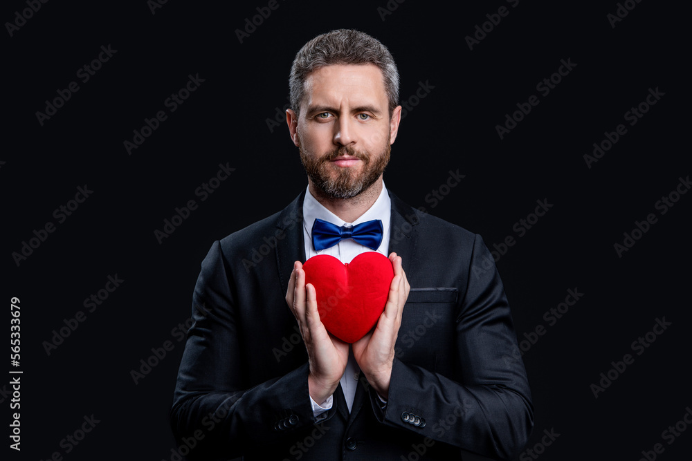 handsome tuxedo man hold proposal love gift in studio. tuxedo man with proposal love gift. handsome tuxedo man hold proposal love gift in studio. tuxedo man with proposal love gift.