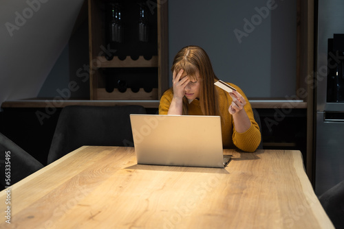Young business frustrated woman annoyed and angry because bank canceled her credit card due to exceeding the allowed limit and minus on the bank account she can't buy and pay online on laptop