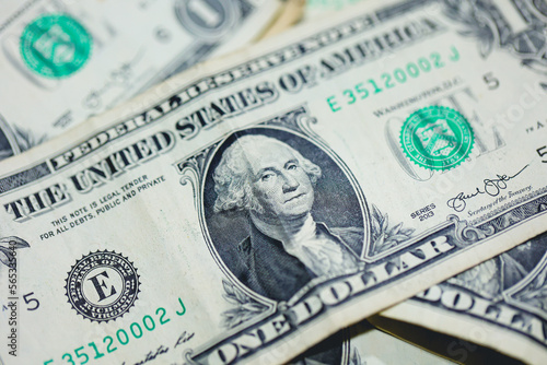 Notas de hum Dólar dos Estados Unidos sobre uma mesa de madeira. Foto com visão de cima. Economia e finanças.	 photo