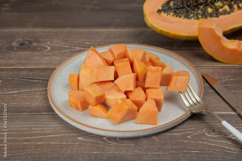 Sliced ripe papaya fruit on white plate with fork ready to eating, Tropical fruit, Top view Sliced ripe papaya fruit on white plate with fork ready to eating, Tropical fruit, Top view