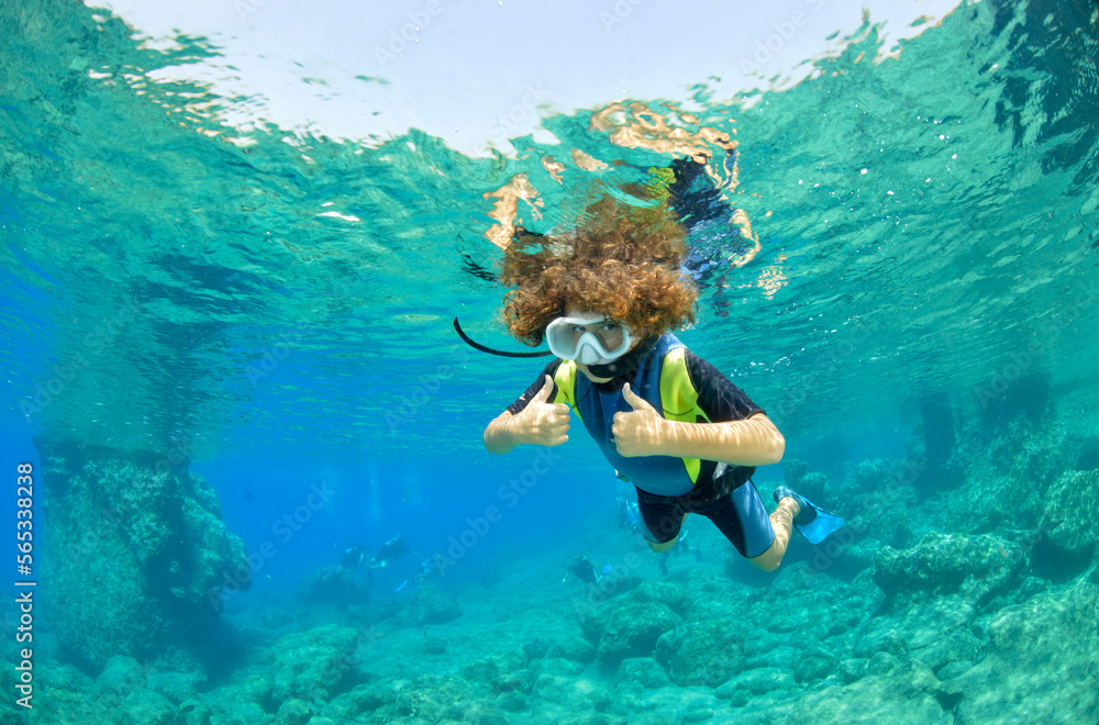 young boy snorkeling in clear waters