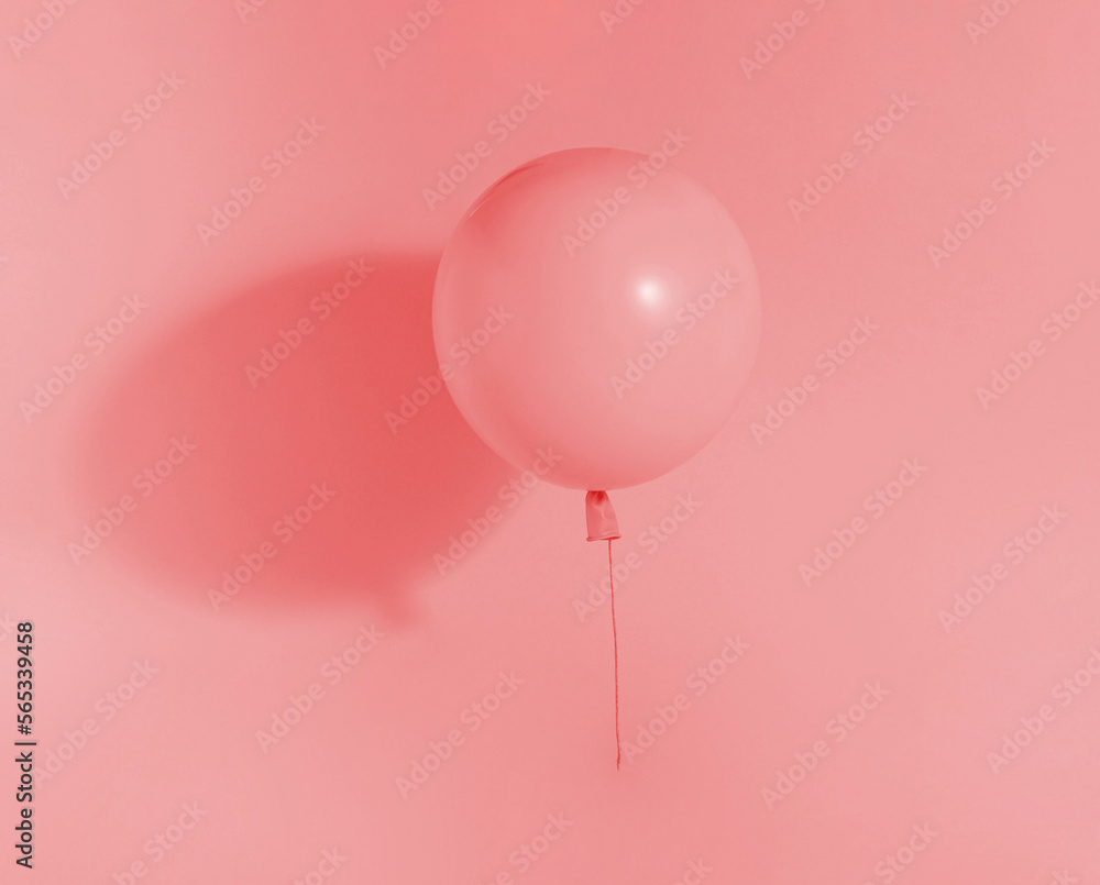 Minimal concept with pink balloon floating in the air next to the wall. Pink background. Minimal concept with pink balloon floating in the air next to the wall. Pink background.