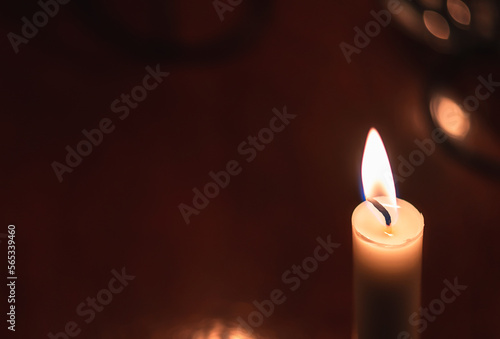 The flame of a burning candle on a dark background.