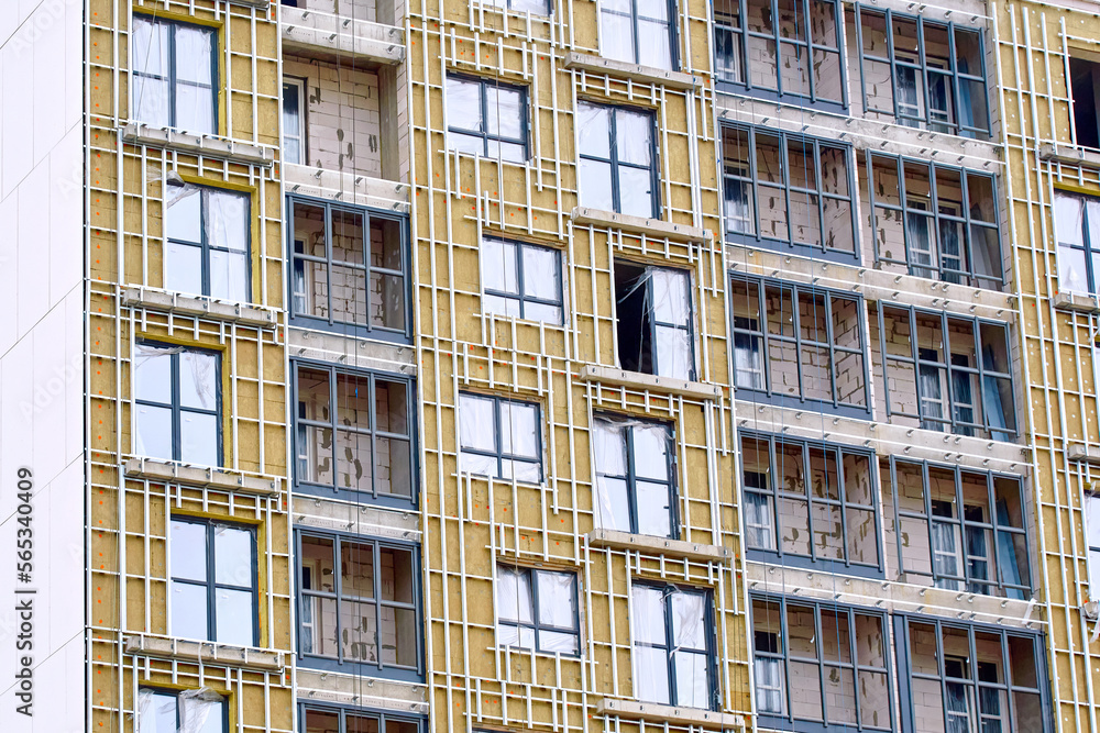 Insulation of residential building, external facade works. Cladding of building, facade insulation, building facing work. Facade wall with frame for facade cladding panels. Thermal wool insulation Insulation of residential building, external facade works. Cladding of building, facade insulation, building facing work. Facade wall with frame for facade cladding panels. Thermal wool insulation