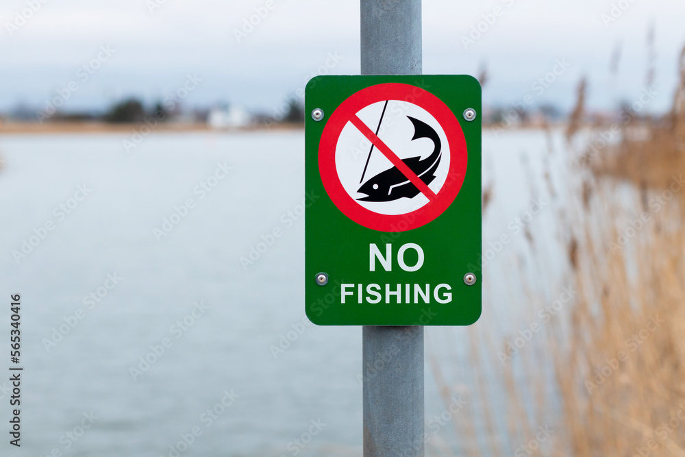Fishing prohibited sign near lake - NO FISHING Fishing prohibited sign near lake - NO FISHING