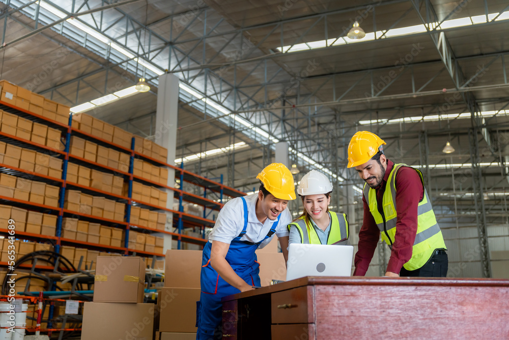 Workers using laptop in warehouse Workers using laptop in warehouse
