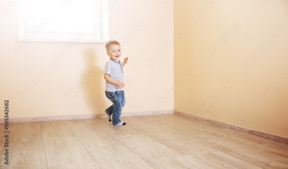 Smiling boy running in empty light room. Smiling boy running in empty light room.