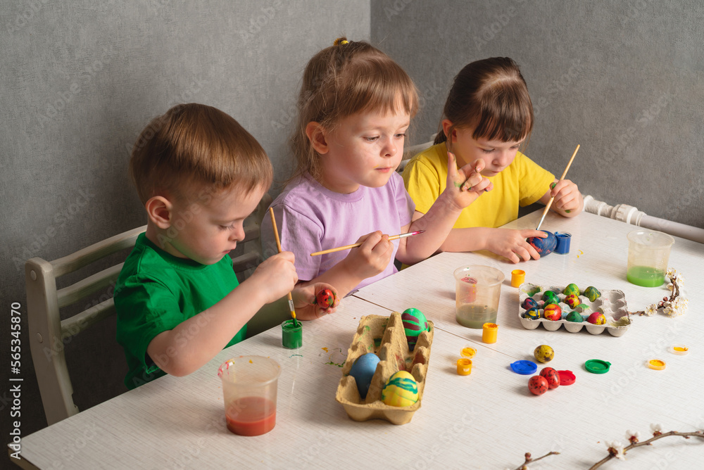 Naklejka premium Children color eggs with food coloring. Getting ready for Easter