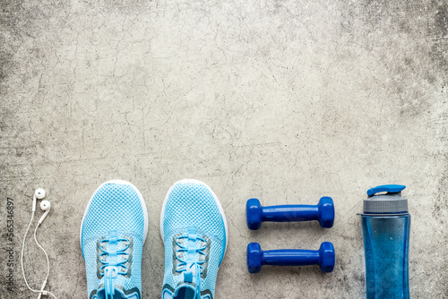 Fototapeta Naklejka Na Ścianę i Meble -  Sport fitness flatlay with sneakers and dumbbells, top view