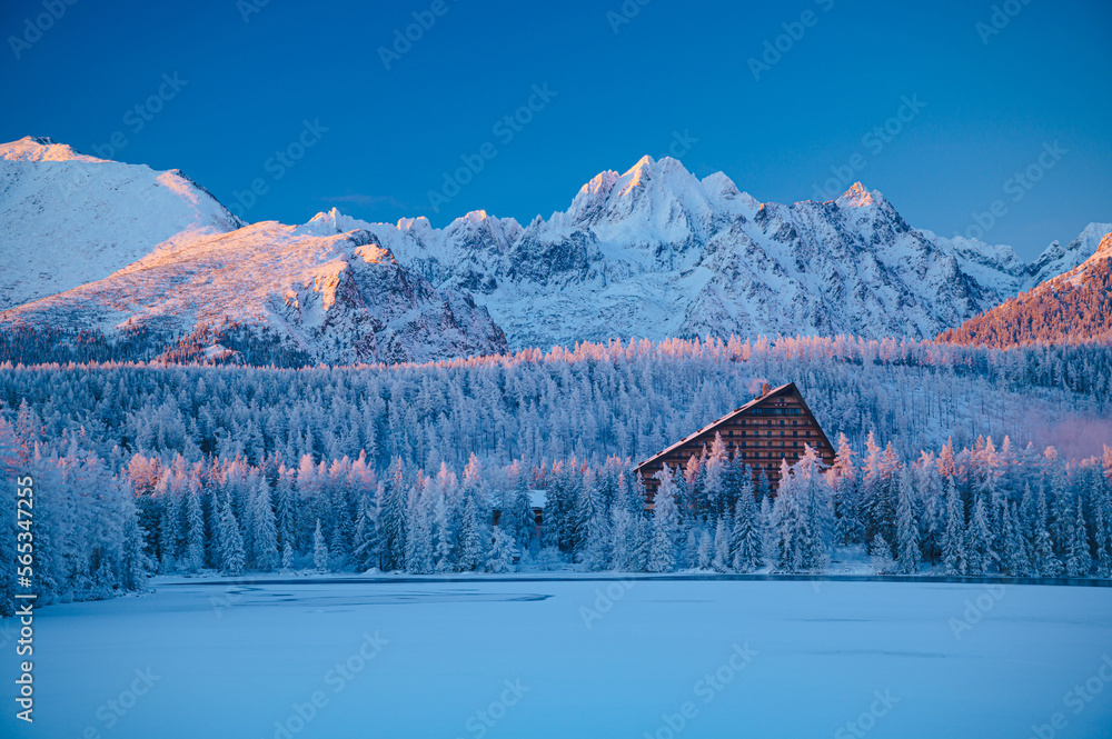 Strbske Pleso lake, nestled in the High Tatras, awakens to a new day as the sun rises on a freezing winter morning