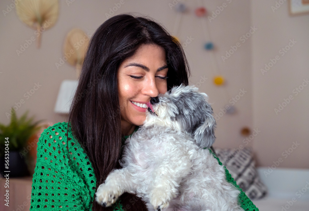 Beautiful Young Woman Hugging her White Senior Havanese Dog at Home 