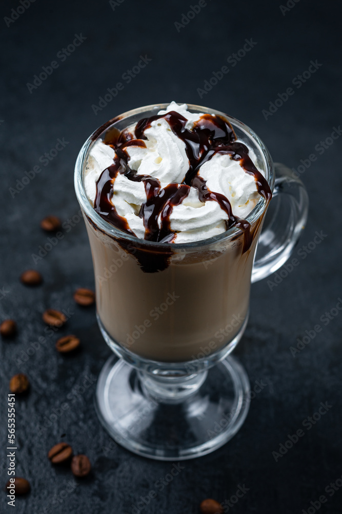 Coffee with cream and chocolate syrup in a mug on dark background. Coffee with cream and chocolate syrup in a mug on dark background.