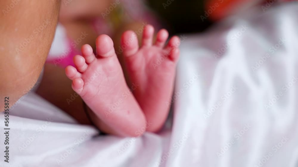 Close up shot of newborn baby feet while sleeping on bed at home - concept of generation, parenthood and beginnings Close up shot of newborn baby feet while sleeping on bed at home - concept of generation, parenthood and beginnings