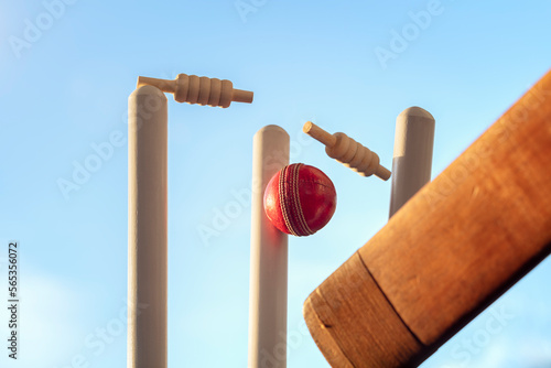 Cricket ball hitting wicket stumps knocking bails out photo