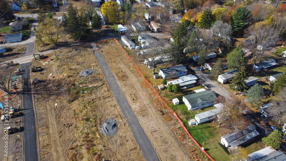 Aerial view construction site of mobile trailer park near complete manufactured houses colorful fall foliage in Rochester, New York
