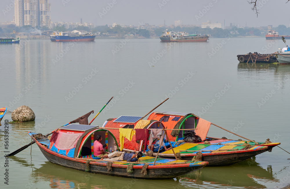 Colorful country boats moored along the shore of the Hooghly River at Calcutta, India