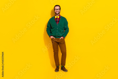 Full body portrait of satisfied glad young man put hands pockets isolated on yellow color background
