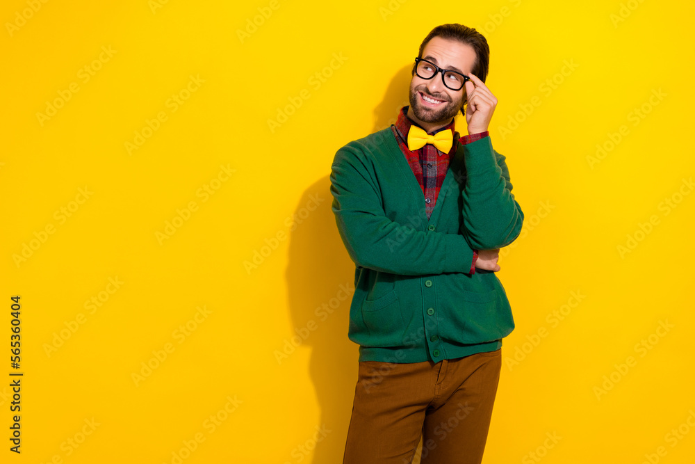 Photo portrait of young attractive male touch fix specs look empty space dressed stylish green garment isolated on yellow color background Photo portrait of young attractive male touch fix specs look empty space dressed stylish green garment isolated on yellow color background