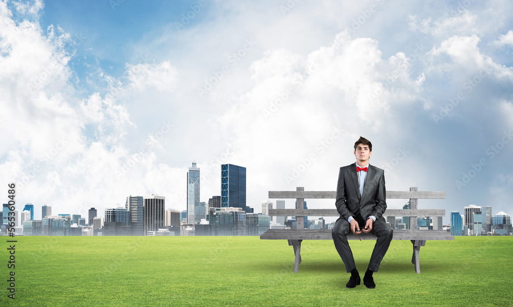 businessman with glasses sits on a wood bench businessman with glasses sits on a wood bench