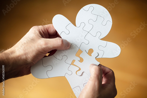 Businessman assembling missing jigsaw puzzle piece human team employee
