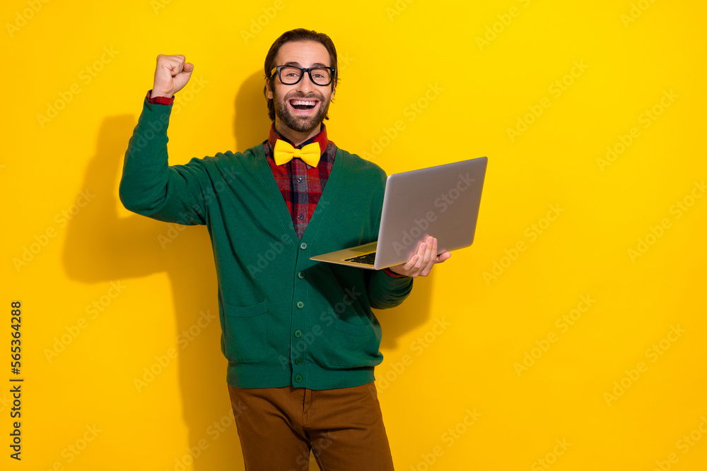 Photo of young gentleman handsome guy wear classy formal cardigan bowtie short celebrate freelancer order laptop isolated yellow color background Photo of young gentleman handsome guy wear classy formal cardigan bowtie short celebrate freelancer order laptop isolated yellow color background