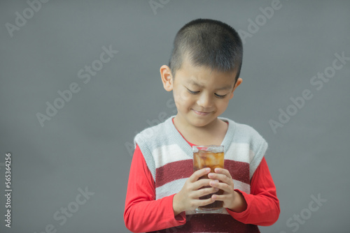 Cute little boy drinking water from glass,Little asian boy drinking soft drink photo