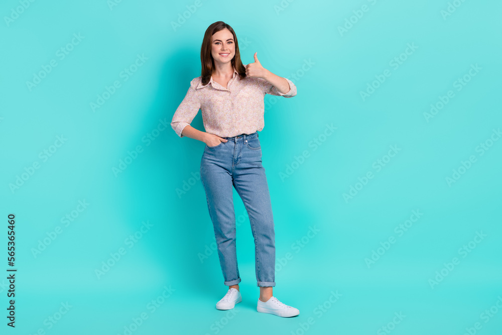 Full length photo of confident cool girl dressed pink shirt showing thumb up smiling isolated teal color background Full length photo of confident cool girl dressed pink shirt showing thumb up smiling isolated teal color background