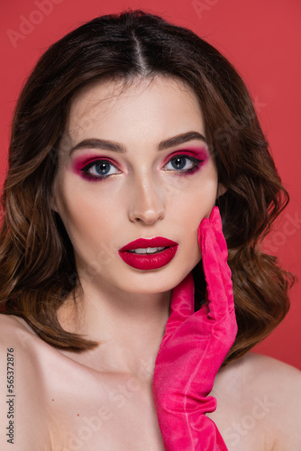 portrait of pretty woman with magenta color eye shadow isolated on pink.