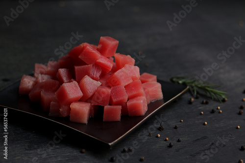 Raw fresh tuna cube on black plate