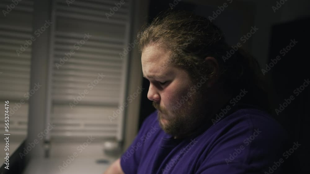 One overweight person suffering alone in front of bathroom mirror. Depression concept of a chubby man facing himself in front of mirror during hard times One overweight person suffering alone in front of bathroom mirror. Depression concept of a chubby man facing himself in front of mirror during hard times