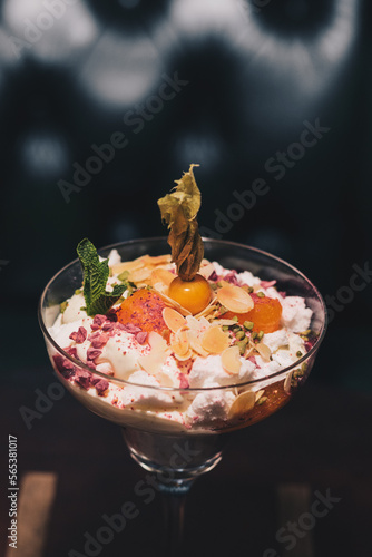 Delicious white dessert in a cocktail glass with a dark background