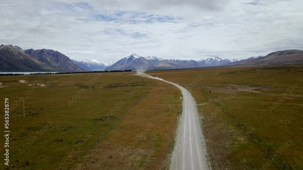 Dusty dirt road with fast vehicle approaching in southern Alps of New Zealand Dusty dirt road with fast vehicle approaching in southern Alps of New Zealand