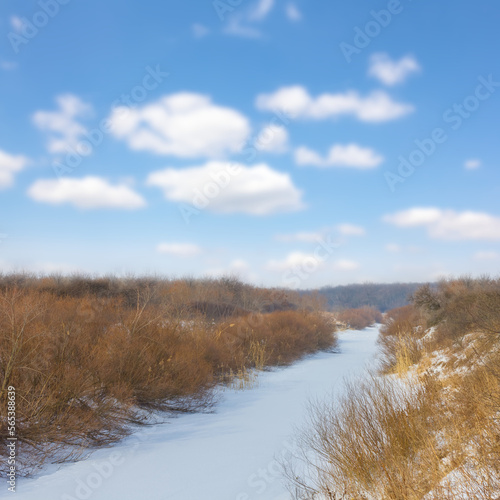 frozen river among prairie at winter day