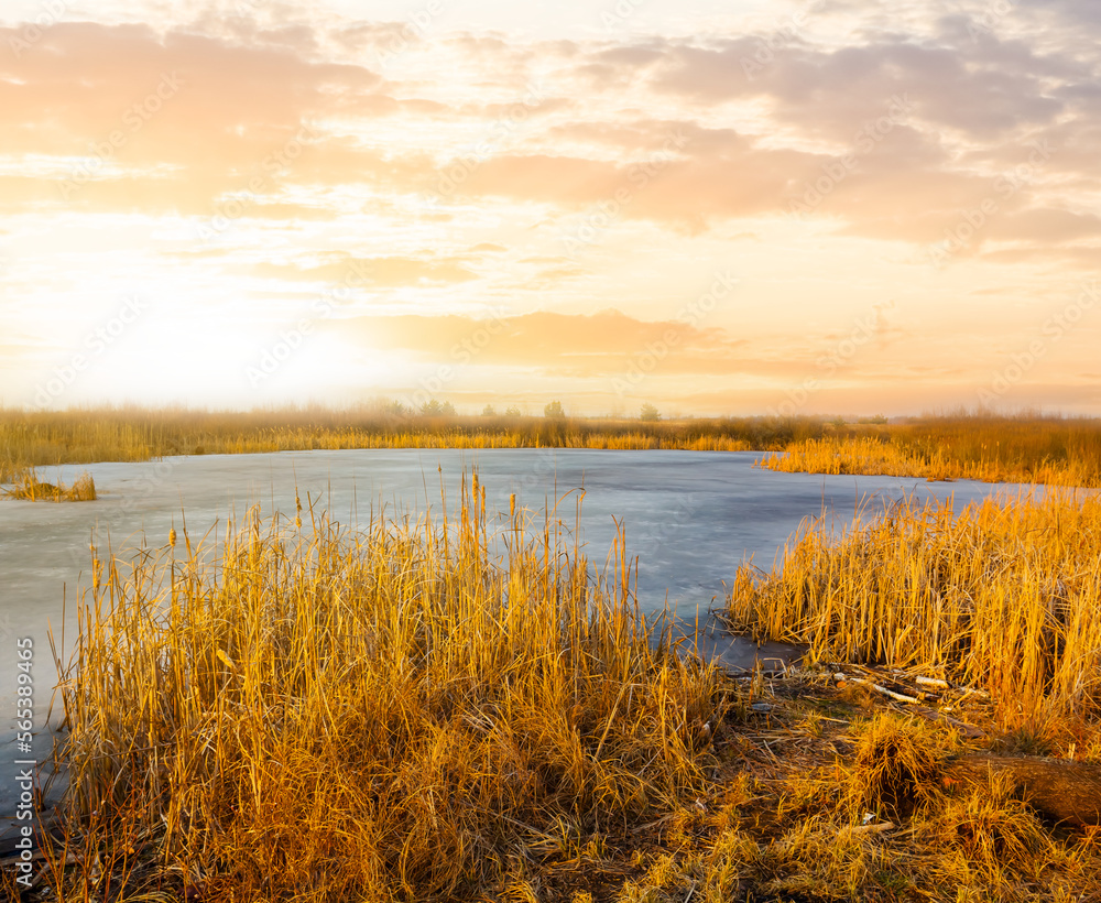 small frozen lake among prairie at the sunset