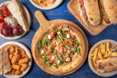 Composition of typical italian street food photographed from above in a blue wooden table 