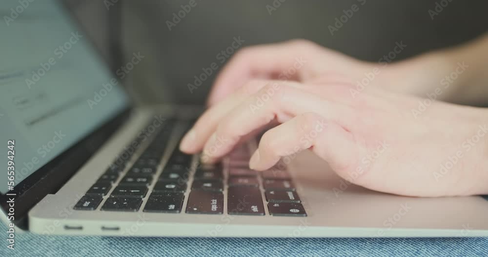 Female fingers typing on a laptop keyboard, side view. The camera focus moves to the distance. Female fingers typing on a laptop keyboard, side view. The camera focus moves to the distance.