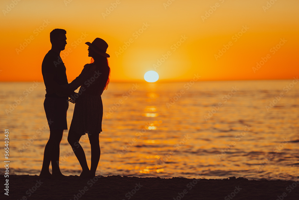 Young couple on white beach during summer vacation at sunset. PHOTO OUT OF FOCUS