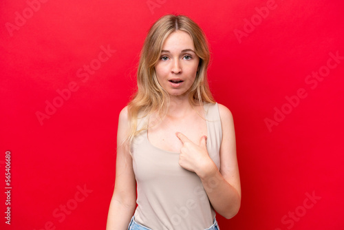 Young English woman isolated on red background pointing to oneself