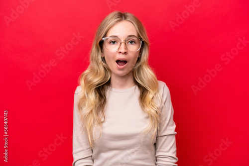 Young English woman isolated on red background With glasses and surprised expression