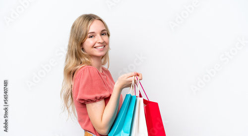 Young English woman isolated on white background holding shopping bags and smiling