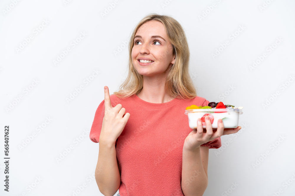 Young English woman holding a bowl of fruit over isolated white background intending to realizes the solution while lifting a finger up Young English woman holding a bowl of fruit over isolated white background intending to realizes the solution while lifting a finger up